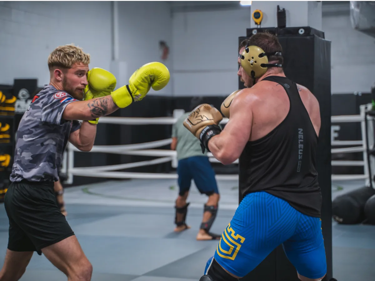 Two members boxing during sparring with gloves and headgear at Furst Place MMA