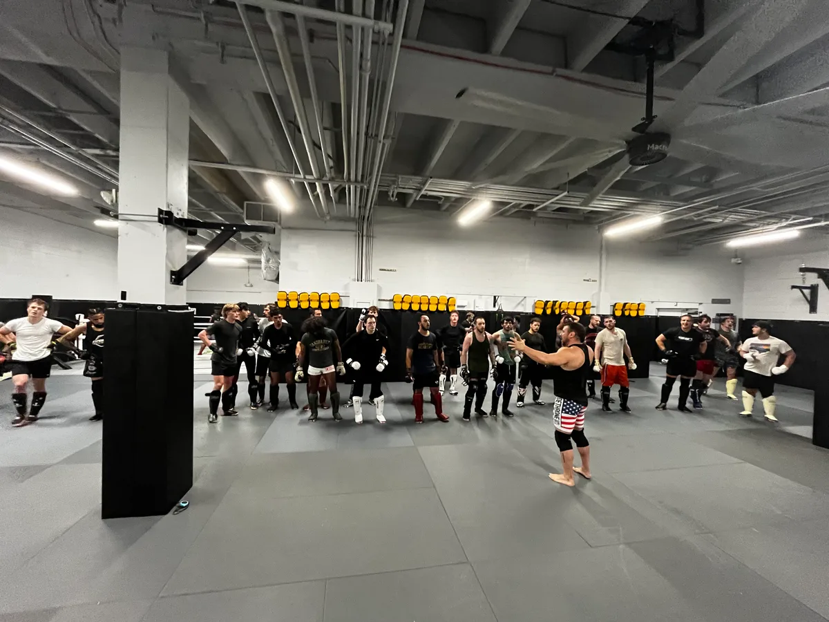 Coach Iron Mike leading a full class of fighters in the training room at Furst Place MMA