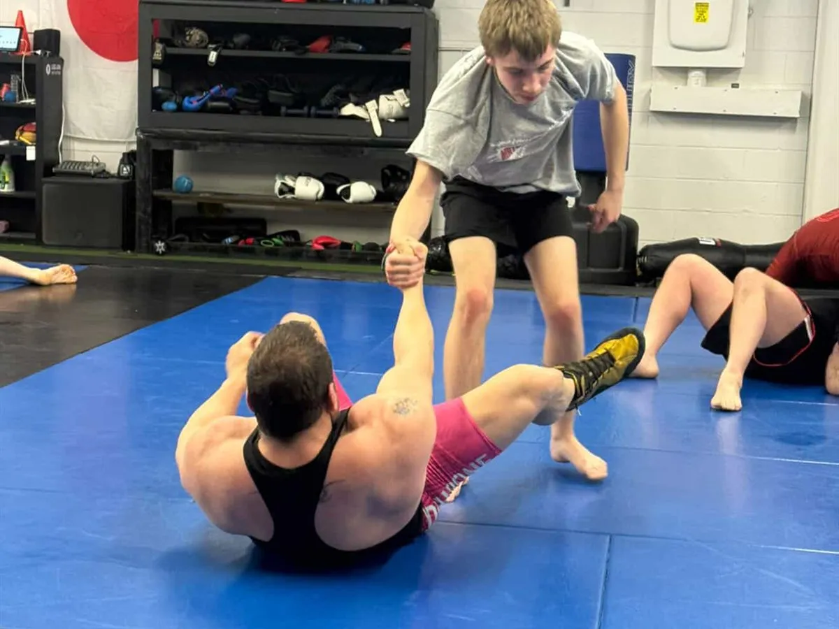 Members wrestling and drilling takedowns on the mats at Furst Place MMA