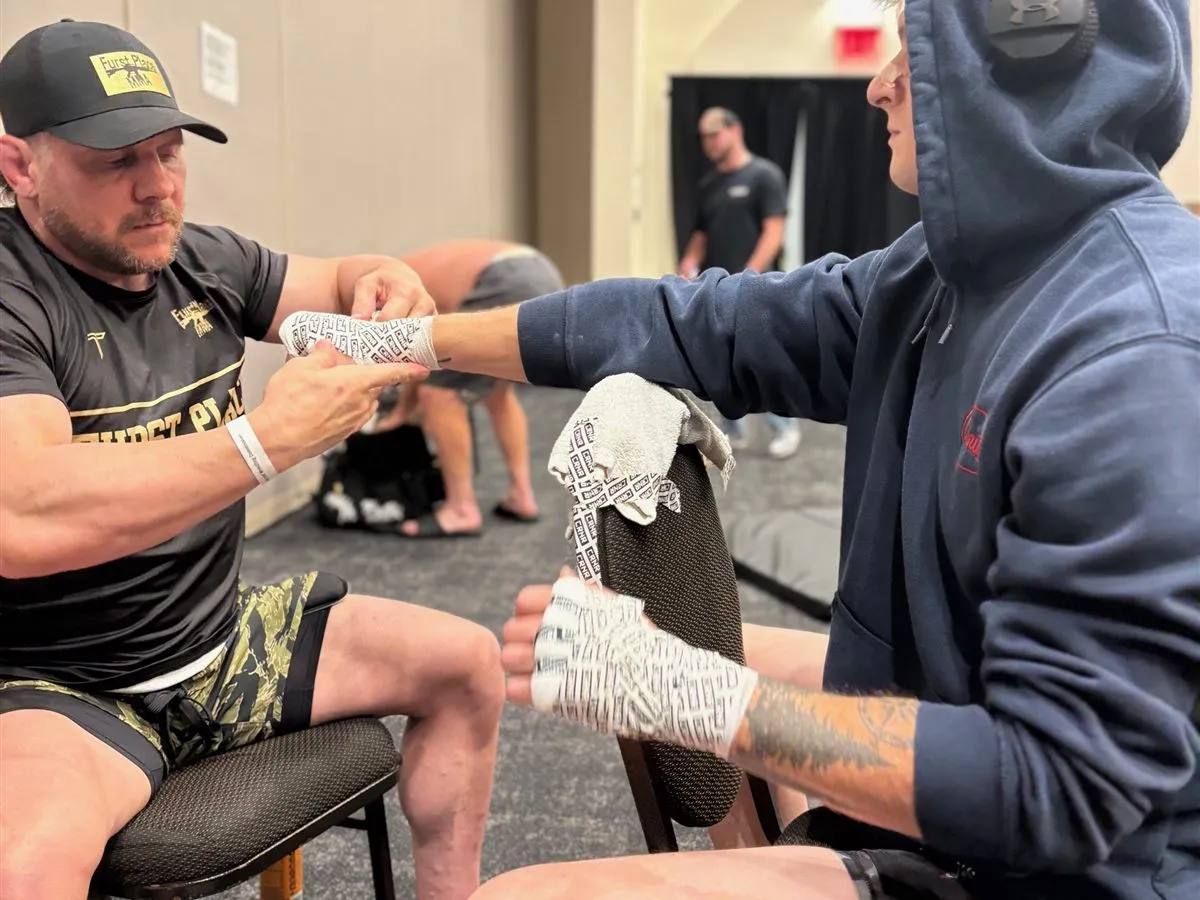 A Furst Place MMA coach taping a fighter's hands before a bout