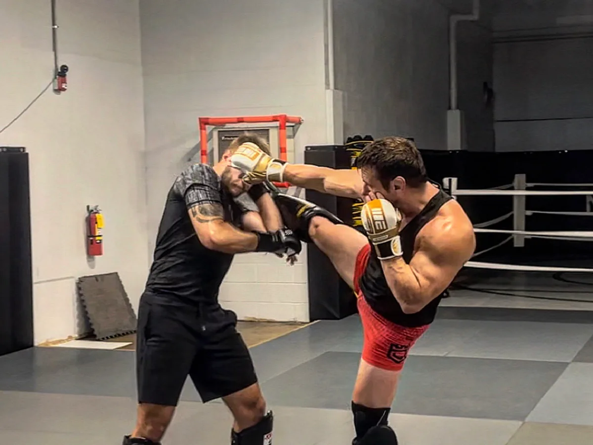 Two members sparring as one lands a high kick at Furst Place MMA