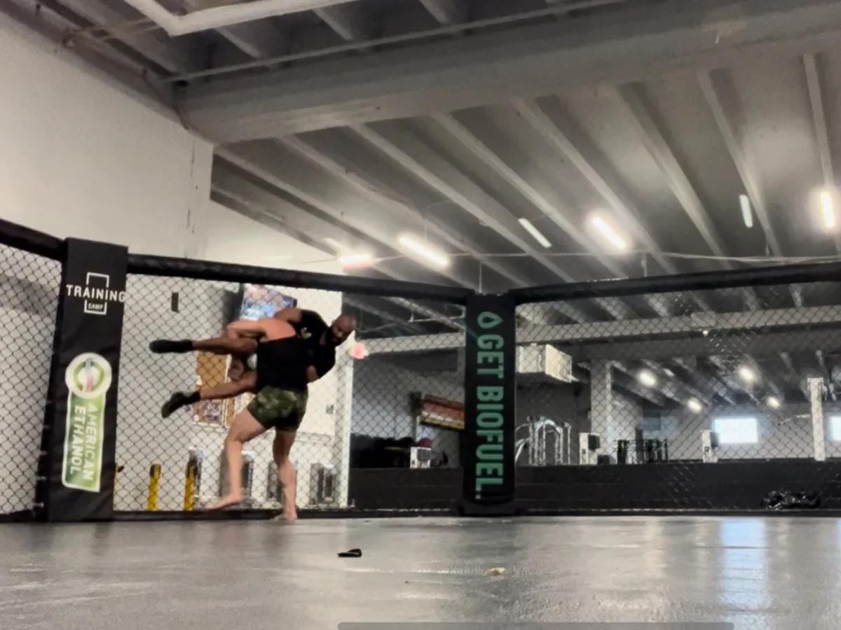 A fighter scoring a takedown inside the training cage at Furst Place MMA